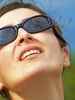 woman with sunglasses looking at sun